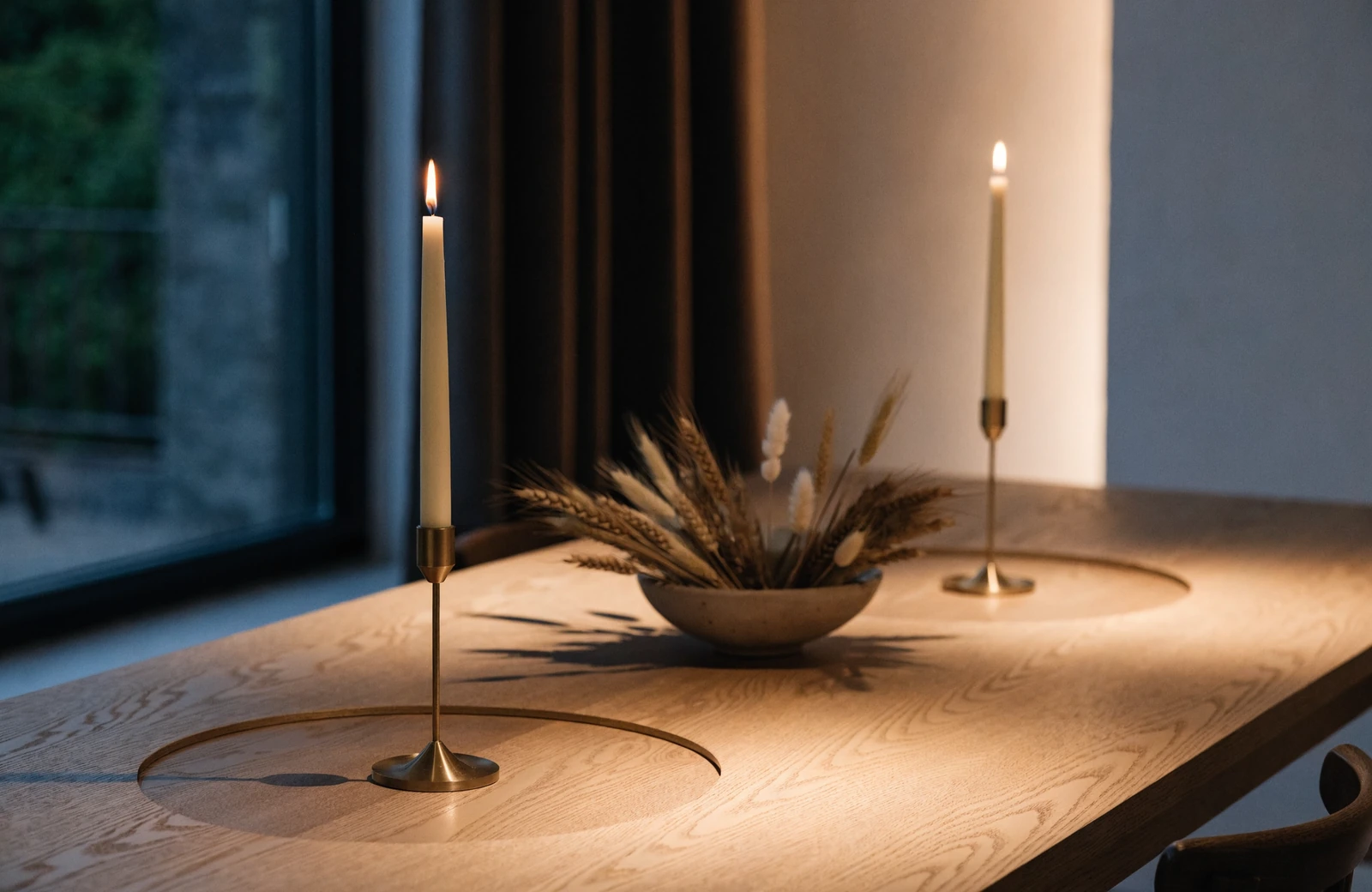 Fall dining table decor with lit taper candles kept clear of a low bowl of dried stems, showing a hand's width of empty table around each flame